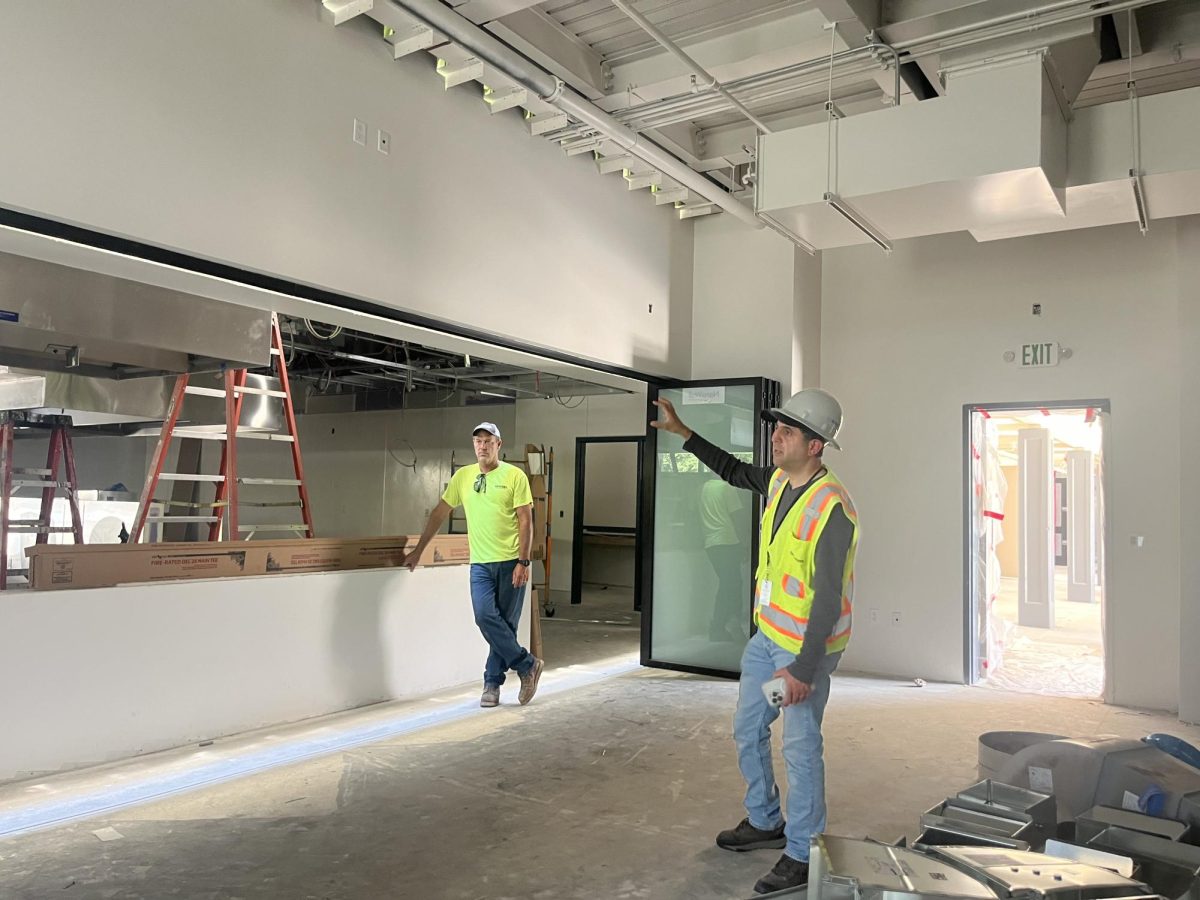 Construction workers discuss their progress with the interior of the food services building and culinary arts classrooms.