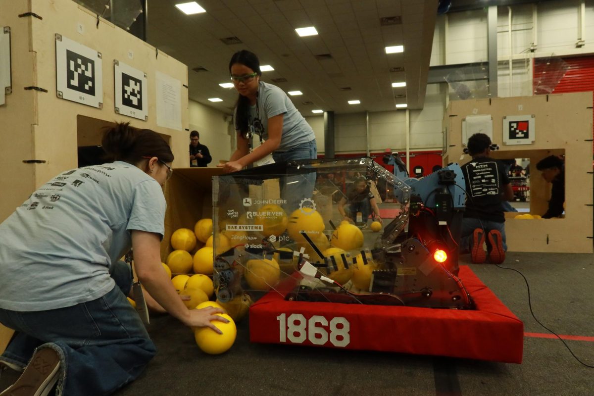 Space Cookies team inserts match load balls into robot on the practice fields, preparing it for the competition.